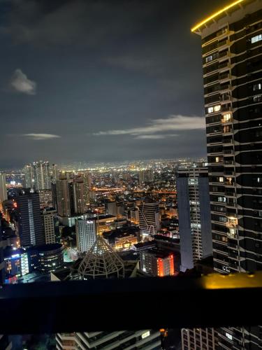 a view of a city skyline at night at Air Residences Airbnb in Manila