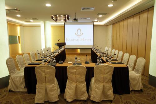 a conference room with a table and chairs and a screen at Badi'ah Hotel in Bandar Seri Begawan