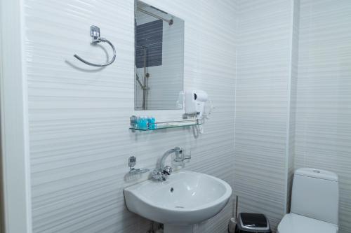 a white bathroom with a sink and a toilet at THE TIME HOTEL in Tashkent