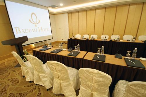a meeting room with a table with chairs and a screen at Badi'ah Hotel in Bandar Seri Begawan