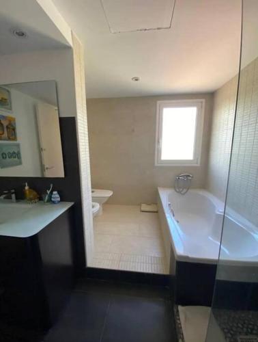 a bathroom with a tub and a sink and a toilet at La Digue Beach House in San Vicente de Calders
