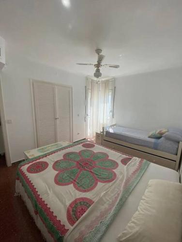 a bedroom with a bed with a flower pattern on it at La Digue Beach House in San Vicente de Calders