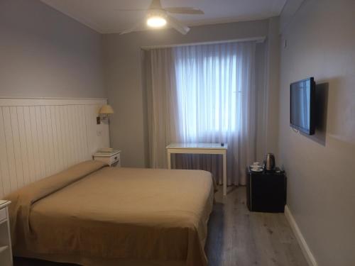 um quarto de hotel com uma cama e uma televisão de ecrã plano em Prince Hotel em Mar del Plata