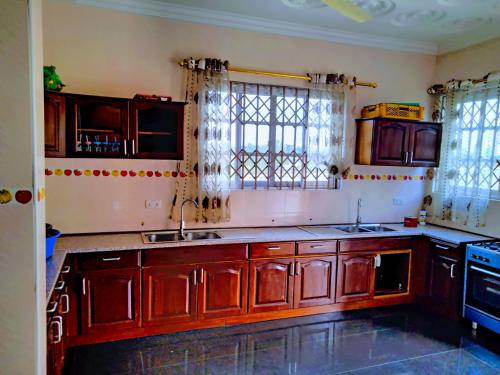 a kitchen with wooden cabinets and a sink at Renajoe Exclusive Centre in Ahwiriso