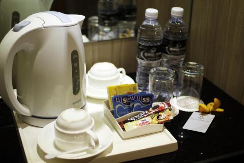 a counter with a coffee maker and some water bottles at Badi'ah Hotel in Bandar Seri Begawan