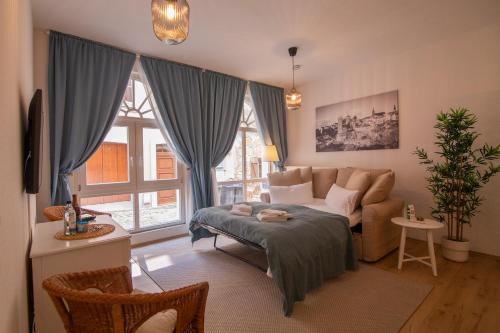 a living room with a bed and a couch at ApartOne Altstadt-Apartments in Bautzen