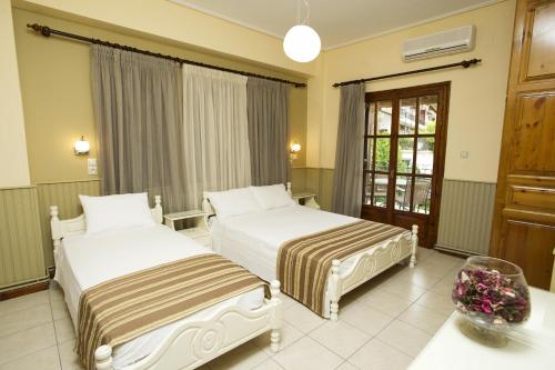 a hotel room with two beds and a table at La Luna in Kala Nera