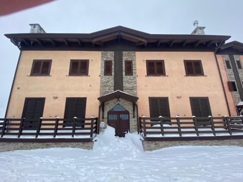 a building with a gate and snow in front of it at Duplex nuovo e grazioso in Capracotta