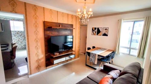 a living room with a couch and a flat screen tv at Apartamento Aconchegante em Paulo Afonso in Paulo Afonso