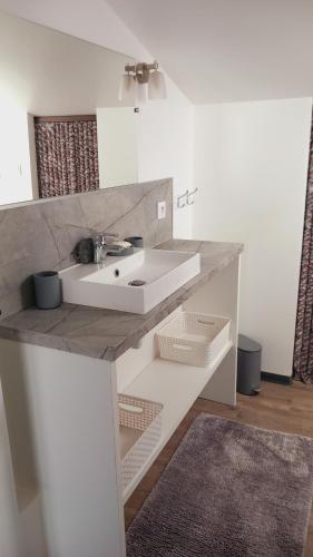 a white bathroom with a sink and a mirror at La colombe in Argelès-sur-Mer