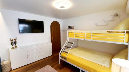 a room with two bunk beds and a tv at Luxuriöse Villa Romantica in Gampel