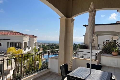 einen Balkon mit einem Tisch und einem Sonnenschirm in der Unterkunft Eleona's Royal Gardens By Yiota - Luxury 2 Bed Apartment in Exclusive Complex in Peyia