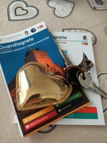 a book and a pair of keys and a heart shapedocket at Romantico Rifugio in Guardiagrele