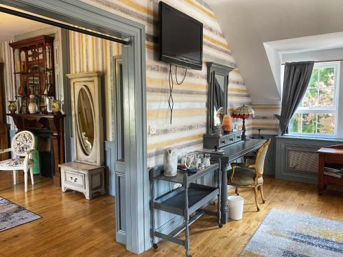een kamer met een bureau en een tv aan de muur bij Dulrush Lodge Guest House, Restaurant and Self-Catering in Belleek