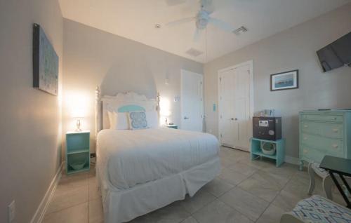 a bedroom with a bed and a dresser and a tv at Sunny Side Cottages in Dunedin