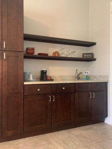 a kitchen with wooden cabinets and a sink at Sunny Side Cottages in Dunedin