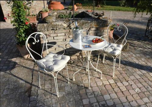 Dos sillas y una mesa con un bol de fruta. en La Bertinora, en Villa Verucchio