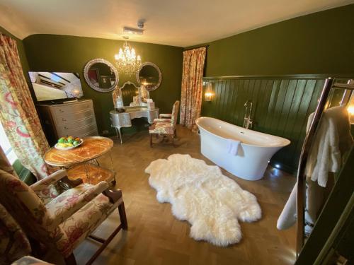 Crayke的住宿－The Durham Ox，带浴缸、水槽和镜子的浴室