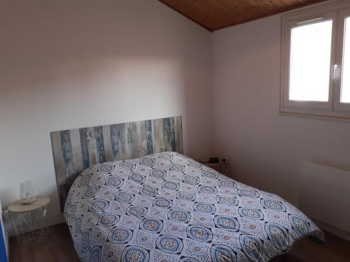 une chambre avec un lit avec une couette et une fenêtre dans l'établissement Le Pélican gîte, à Les Sables-dʼOlonne