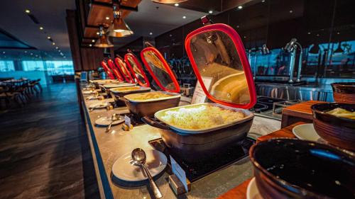 a row of bowls of food on a buffet line at FUGO Hotel Samarinda in Samarinda