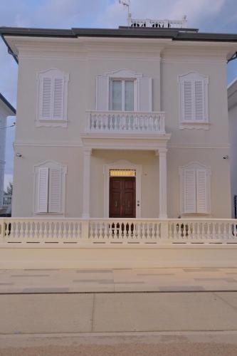 a white house with a balcony and a door at Villa La Torretta Luxury B&B - Adults Only - in Rimini