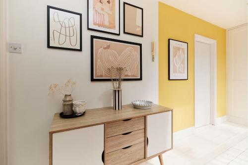 um quarto com uma mesa com pinturas na parede em The Hampstead Wonder - Spacious 4BDR House with Balcony em Londres