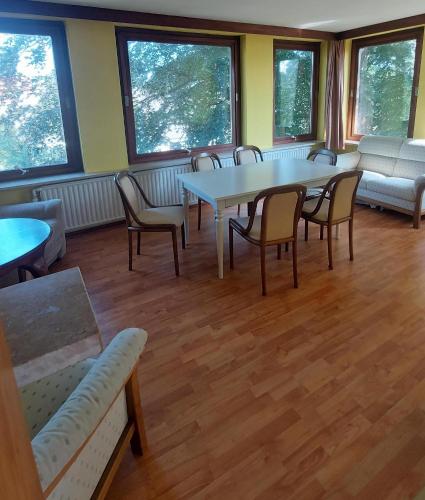 a waiting room with tables and chairs and windows at Haus Bergfried in Scharbeutz