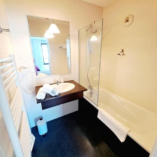 une salle de bain avec un lavabo et une douche dans l'établissement Le Valmy: appartement lumineux au pied du métro, à Lyon