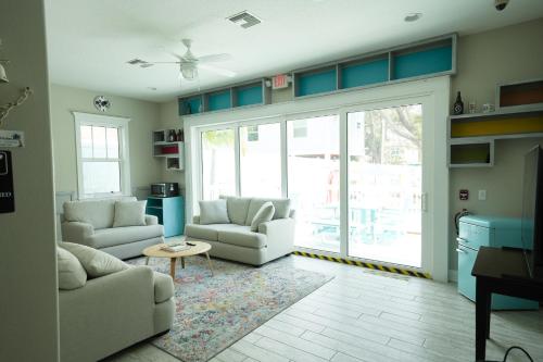 a living room with two couches and a sliding glass door at Sunny Side Cottages in Dunedin
