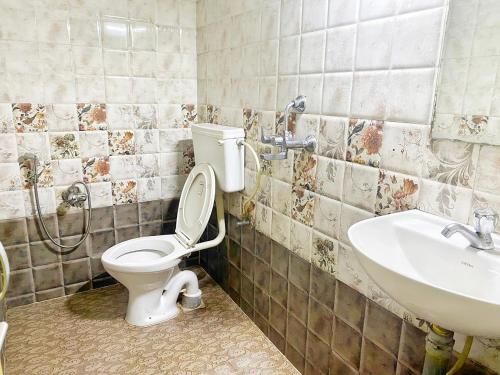 a bathroom with a toilet and a sink at Baga Beach Paradise in Baga