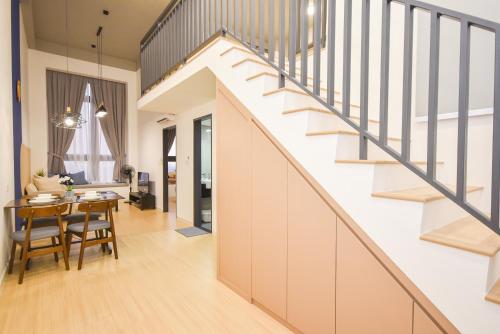 a staircase in a home with a dining room and a living room at Sunway Grid Loft Suite by Nest Home【Olympic Size Pool】 in Kampong Pendas