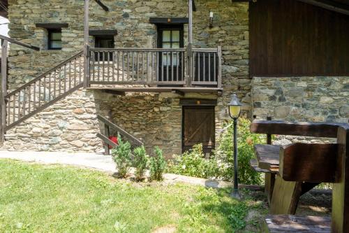 a stone building with a staircase and a balcony at Residence Covalou in Antey-Saint-André