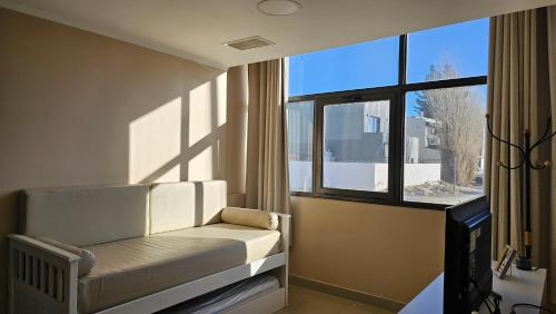 a room with a bed in front of a window at CONDOR Patagonia Aparts in El Calafate