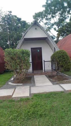 a small white house with a brown door at Eco Hotel Villas del Tortuguero in Cariari