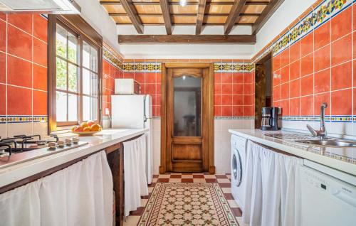 a kitchen with white appliances and orange tiled walls at EL PAISANO in Prado del Rey