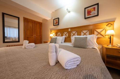a bedroom with a large bed with white pillows at Altos Ushuaia Hotel & Resto in Ushuaia