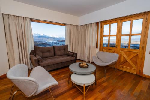 a living room with a couch and chairs and a table at Altos Ushuaia Hotel & Resto in Ushuaia