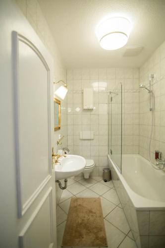 a bathroom with a tub and a sink and a toilet at ApartOne Altstadt-Hotel in Bautzen