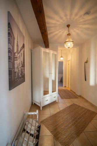 a room with a ladder and a chandelier and a hallway at ApartOne Altstadt-Hotel in Bautzen