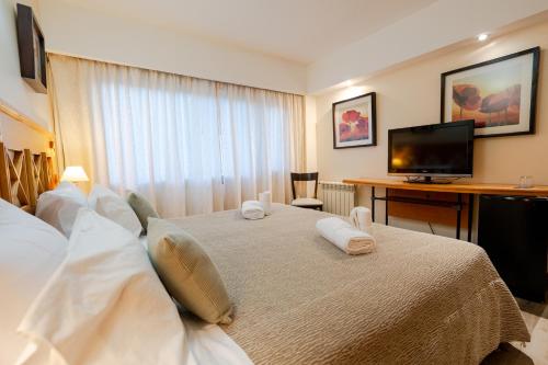 a hotel room with a bed and a television at Altos Ushuaia Hotel & Resto in Ushuaia