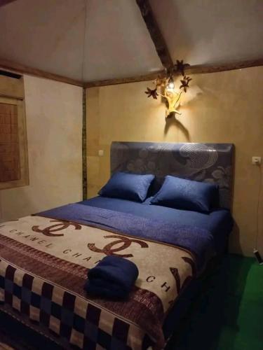 a bedroom with a large bed with blue pillows at New Rinjani Homestay in Tetebatu