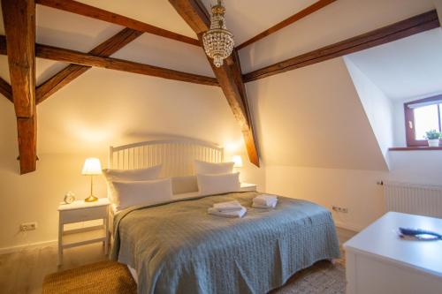 a bedroom with a bed in a room with wooden ceilings at ApartOne Altstadt-Hotel in Bautzen