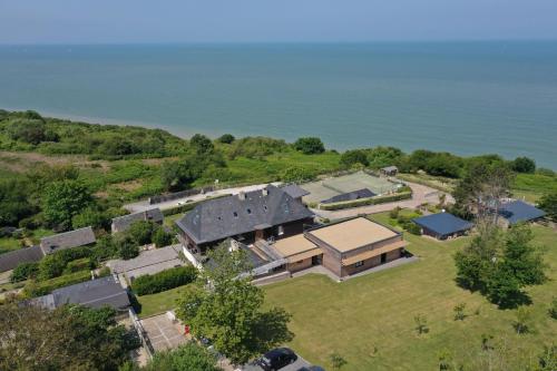 an aerial view of a house on a hill next to the water at Domaine du Grand Bec in Villerville