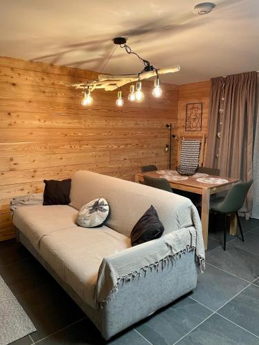 - un canapé dans une pièce avec une table dans l'établissement Studio neuf et chaleureux, à Vars