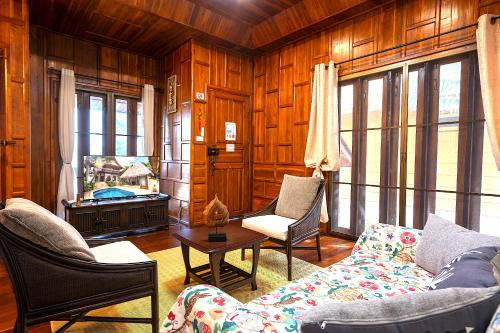 a living room with a couch and chairs and a television at Villa Ayutthaya, Private Pool Near Kantiang Beach in Ko Lanta