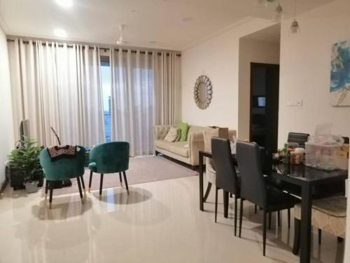 Luxury Sea view fully furnished apartment في كولومبو: غرفة معيشة مع طاولة وكراسي وأريكة