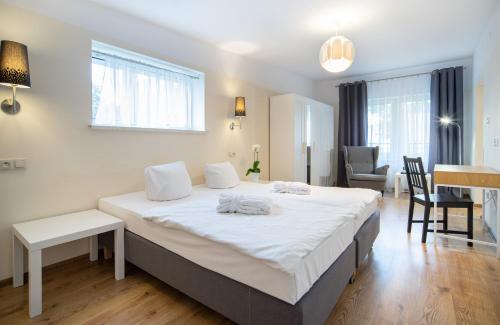 a bedroom with a large white bed in a room at Fala by Marena Wellness & Spa in Międzywodzie