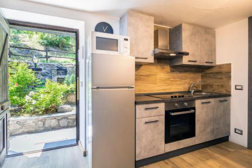 a kitchen with a refrigerator and a window at Residence Covalou in Antey-Saint-André
