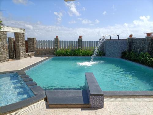 a swimming pool with a water fountain at BareFootBay - Villa with Private Beach Access in Chennai