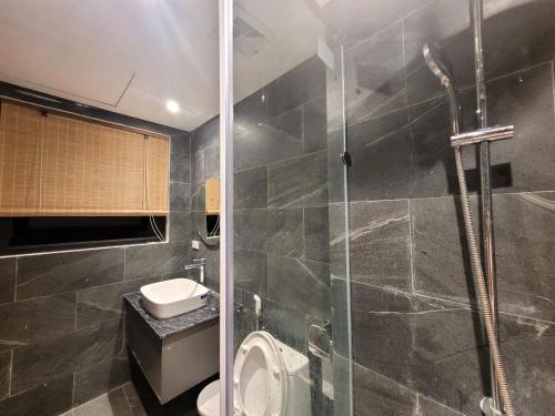 a bathroom with a toilet and a glass shower at Noi Bai Flight Path Homestay in Hanoi